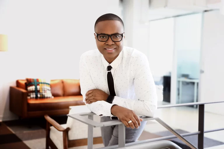 A well dressed business man leaning on a desk