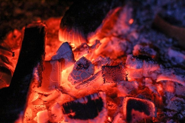 A close-up of charcoal briquettes piled in a bag, ready for a backyard grill.