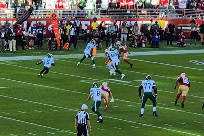An empty NFL stadium bench dusted with snow under stadium lights