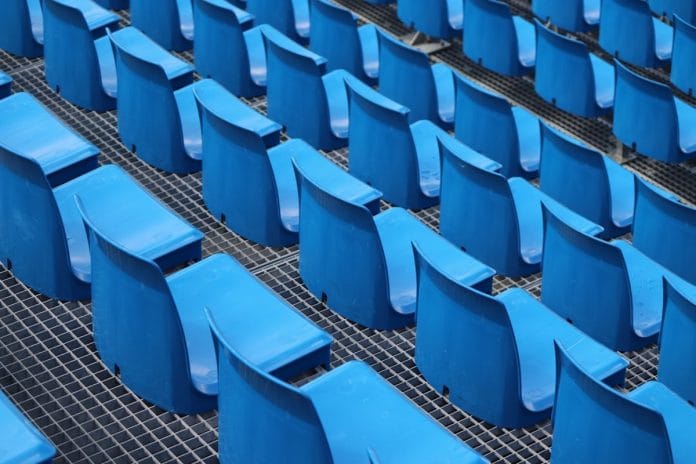 Preseason Sideline, Starters Not Pictured An NFL sideline bench sits empty during a preseason game under stadium lights.