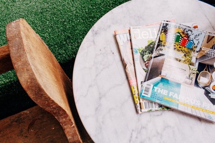 Sunday morning at the kitchen table A copy of a sports magazine open on a sunlit kitchen table with a coffee mug beside it