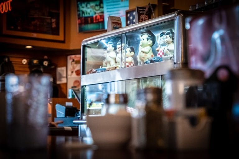 A worn coffee cup and newspaper on the counter of a small-town diner in the morning