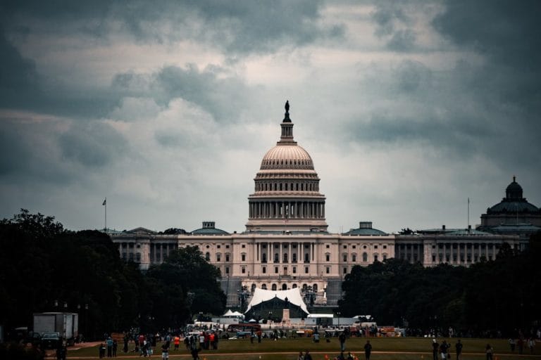 National Guard troops in fatigues stand near a federal building in Washington DC under an overcast sky