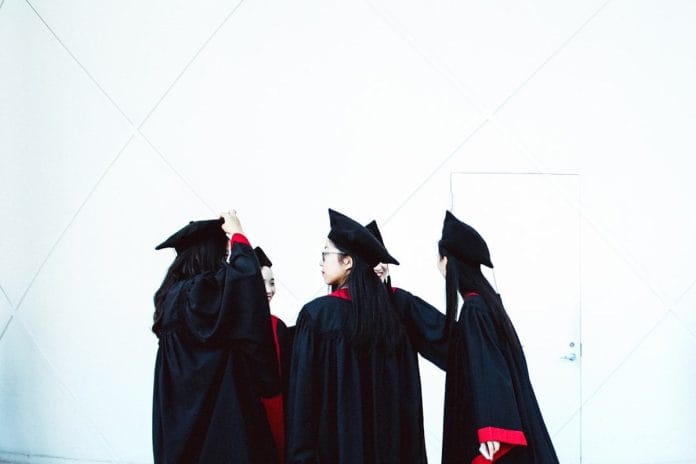 A graduate's mortarboard cap with tassel mid-flip during a commencement ceremony