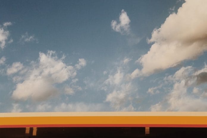 The Sunoco Where Uncle Frank Says It Happened A weathered American gas station at dusk along an interstate, the kind of nondescript roadside stop where every uncle claims to have met a wrestler