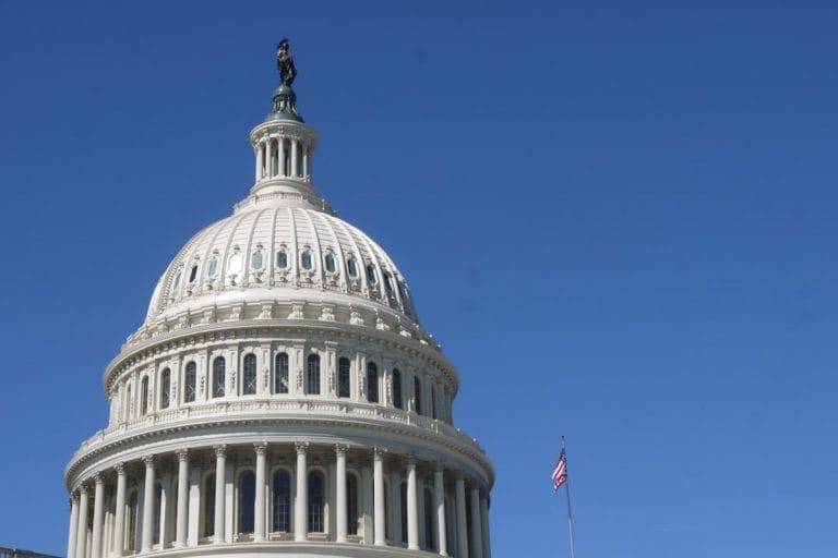 The United States Capitol dome illuminated against a dark winter sky