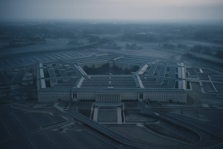 Aerial overhead view of the Pentagon building at a cold blue dawn with empty parking lots and long winter shadows.