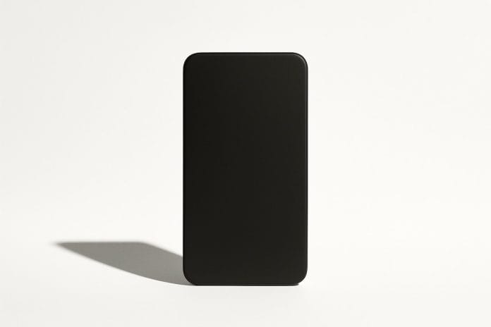 A single matte black smartphone-shaped rectangle centered on a white studio background with a hard shadow.